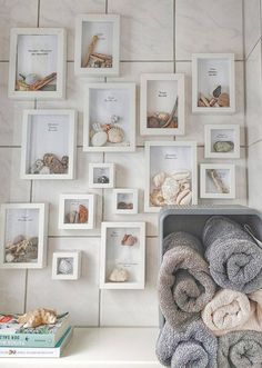 there are many pictures on the wall with towels and seashells in them,