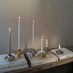 three candles are sitting on top of books