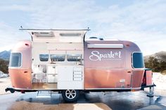 a pink and white trailer parked in the snow