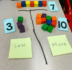 a table topped with lots of colorful pieces of paper next to numbers and magnets