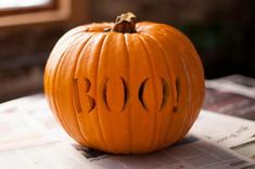 a carved pumpkin sitting on top of a newspaper