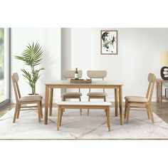 a dining room table with chairs and a potted plant in the corner next to it