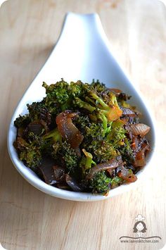 a white bowl filled with broccoli on top of a wooden table