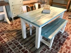 a wooden table with two benches on top of it in a room filled with furniture