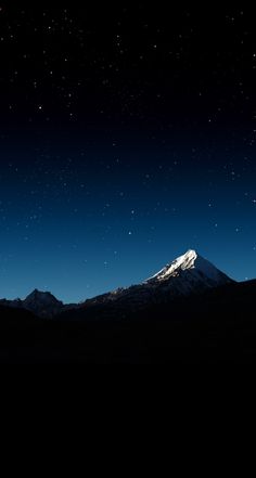 the night sky is lit up with stars above mountains and snow - capped mountain tops