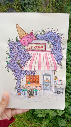 a person holding up a drawing of a ice cream shop with lilacs on it