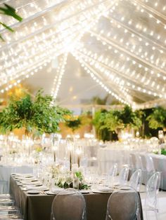 the tables are set with clear chairs and white tablecloths for an elegant wedding reception