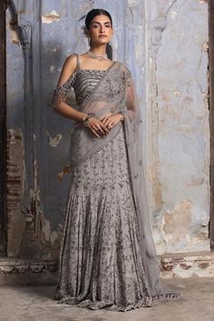 Grey georgette draped lehenga saree embroidered in gun metal and silver dori, beads and crystals. Paired with net cold shoulder blouse.
Components: 2
Pattern: Embroidered
Type Of Work: Bead,Dori,Crystals
Neckline: Asymmetric
Sleeve Type: Sleeveless
Fabric: Saree: Georgette, Blouse: Net and Lining: Shantoon
Color: Grey
Other Details: 
Net palla
Faux feather border
Occasion: Cocktail,Reception - Aza Fashions Drape Lehenga, Drop Shoulder Blouse, Net Blouse, Draped Saree, Grey Saree, Net Blouses, Bridal Lehenga Red, Drape Saree, Ready To Wear Saree