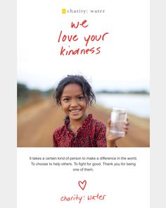 a girl holding a glass of water with the words charity water in red and white