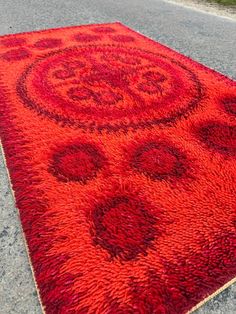 a red area rug on the side of a road