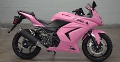 a pink motorcycle is parked in a garage