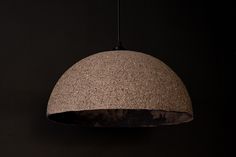 a concrete light hanging from a black ceiling