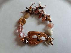 Handcrafted Ceramic Focal by CarlehsCreations with Tiger Eye,  Agates, seeds, Czech Glass and copper toggle in Knotted Bracelet. Knotted Bracelet, Golden Tiger, Hippie Bracelets, Bracelet Knots, Handcrafted Ceramics, Custom Bracelets, Czech Glass Beads, Bracelet Designs, Tiger Eye