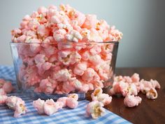 a glass bowl filled with pink popcorn sitting on top of a table