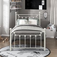 a white metal bed in a bedroom with grey walls and wooden floors, along with a rug on the floor