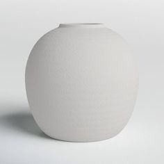 a white vase sitting on top of a table