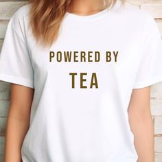 ----- The Design ----- For those who can't or won't start their day without a nice cup of tea! Are you blissfully aware that the day only truly starts after your first sip of tea? Then this tea tee was made for you! Our "Powered by Tea" unisex t-shirt has an apt, relatable message perfect for any tea lover, caffeine addict or proper brew aficionado!  Why You'll Love It: ☕️ Everyday Style: Make every tea & coffee run stylish and fun with this "Powered by Tea" t-shirt! Whether you're treating your Tea Humor, Tea And Biscuits, Caffeine Addict, Cuppa Tea, Fun Cup, Limassol, Cup Of Tea, Tea Lover, Everyday Style