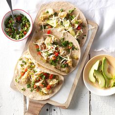 three tortillas on a cutting board with avocado and salsa