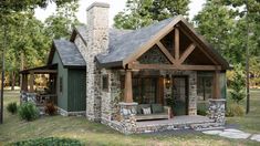 a small house with a porch and stone pillars in the front yard, surrounded by trees