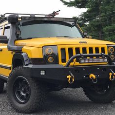 a yellow jeep is parked in the parking lot