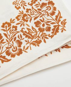 two napkins with orange and white designs on them