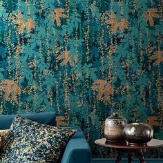 The Canopy Wallpaper, in Peacock, features gold accents that captures the vibrant elegance of nature. Designer Clarissa Hulse became entranced by the intricate patterns of the forest canopy while out walking in the woodlands of Wiltshire. You will find your eyes are drawn to the luxuriant foliage of this captivating wallpaper, where every leaf, stem and vine layer over one another to create exquisite patterns. With a subtle sheen and a soft textured finish, this wallpaper will elevate any living space. Graham & Brown Clarissa Hulse 20.5-in Peacock Non-woven Textured Floral 56-sq ft Unpasted Paste The Wall Wallpaper Sample in Blue | 12039394 Teal Blue Peel And Stick Wallpaper, Blue Peel And Stick Wallpaper, Clarissa Hulse, Peacock Wallpaper, Forest Canopy, Graham Brown, Graham & Brown, The Woodlands, Wallpaper Direct