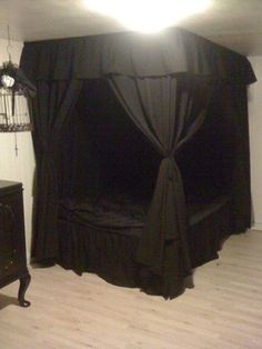 a bed with black drapes on top of it