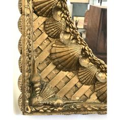 an ornate gold frame with seashells on the edges and in between it is a mirror