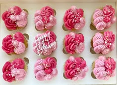 cupcakes decorated with pink frosting in a box for a birthday or special occasion