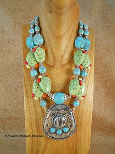 Check out this cute, chunky, double strand, rodeo cowgirl necklace!! I put it together using some ceramic Prickly Pear or Nopal Cactus pads with cactus flowers in yellow, orange & red, large turquoise Impression Jasper ovals and graduated sizes of turquoise howlite rounds including a large center bead.  The focal point of this gorgeous piece is a silver plated Sombrero or Cowboy Hat pendant that is set with 3 small turquoise howlite cabochons.  Lots of nice Tibetan silver spacer beads and bead c Handmade Western Style Jewelry For Festival, Handmade Western Jewelry For Festival, Western Style Handmade Festival Jewelry, Handmade Western Turquoise Necklace For Festival, Western Multicolor Necklaces For Festival, Handmade Western Style Necklace, Western Style Multicolor Necklace For Festival, Western Multicolor Necklace For Festivals, Multicolor Western Style Festival Necklaces