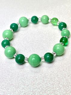 "Venetian Glass stretch bracelet in shades of green.  Alternating beads features shades of e-mails and opaque spring green. Each bead is handmade. Alternating shades of emerald and opaque light green add to this bracelet's interest This beautiful, handmade bracelet is suitable for all occasions and perfect size for most wrists. Measures 7.25\" Arrives in gift box, ready for gifting. Great for any occasion and nature-lovers, St Patrick's Day, love, friendship, mothers, daughters, birthday." Elegant Green Stretch Bracelet With Round Beads, Elegant Green Stretch Bracelet Gift, Green Jade Stretch Bracelet With Round Beads, Green Round Beads Bracelet As Gift, Trendy Green Beaded Bracelets As Gift, Trendy Green Beaded Bracelet For Gift, Trendy Green Hypoallergenic Beaded Bracelets, Casual Green Jade Jewelry, Casual Green Hypoallergenic Bracelet