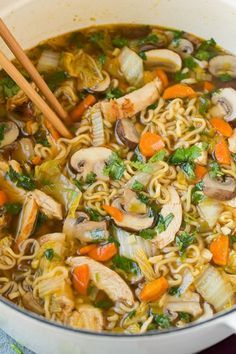 a pot filled with noodles, carrots and mushrooms