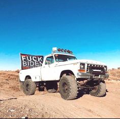 a white truck driving down a dirt road next to a sign that says flickr bidex