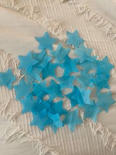 blue paper stars are scattered on a white blanket