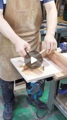 a man in an apron working on a piece of wood with a circular sawhorse