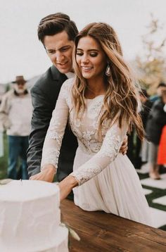 a newly married couple cutting their wedding cake