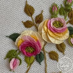 two pink and yellow flowers on white fabric