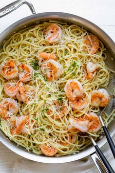 pasta with shrimp and parmesan cheese in a skillet on a white table