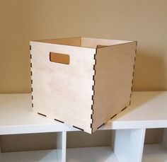 a wooden box sitting on top of a white shelf