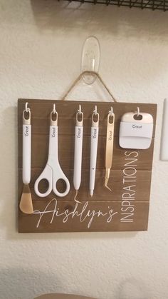 a wooden sign with scissors hanging from it's side