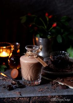 there is a glass jar with chocolate in it on the table next to some candles