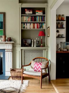 a living room filled with furniture and a fire place in front of a book shelf