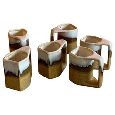 four brown and white vases sitting next to each other