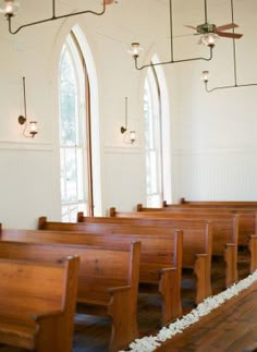 an empty church with wooden pews and stained glass windows