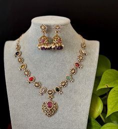 Elegant Victorian finished CZ  Navaratna necklace with matching Earrings is an elegant set for your local gatherings or parties! Length of the earrings: 4.5 cm Width of the earrings: 2 cm Care Instruction : Avoid Heat & Chemicals Like Perfume, Deo, Alchol, Etc. | Clean With Dry Cotton Cloth | Pack In our Anti tarnish box after use. Navaratna Gold Necklace Indian, Ornate Cutdana Necklace Gift, Victorian Jewelry Indian, Navaratna Necklace, Ornate Pendant Necklace For Diwali, Festive Ornate Hand-set Temple Necklace, Gold Navaratna Necklace, Indian Necklace, Cz Necklace