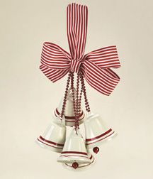 three bells tied up to each other with red and white ribbons hanging from the top