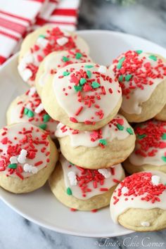 a white plate topped with cookies covered in frosting and sprinkles on top of a table