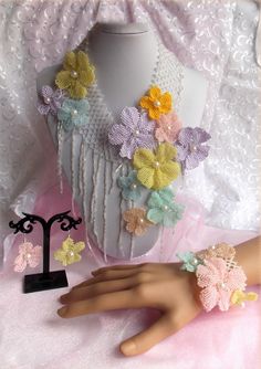 a white mannequin with multicolored crochet flowers on it's neck