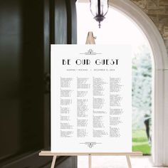 a white sign sitting on top of a wooden easel in front of a doorway