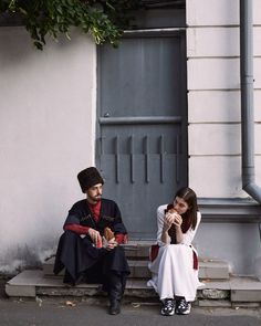 a man and woman sitting on steps next to each other